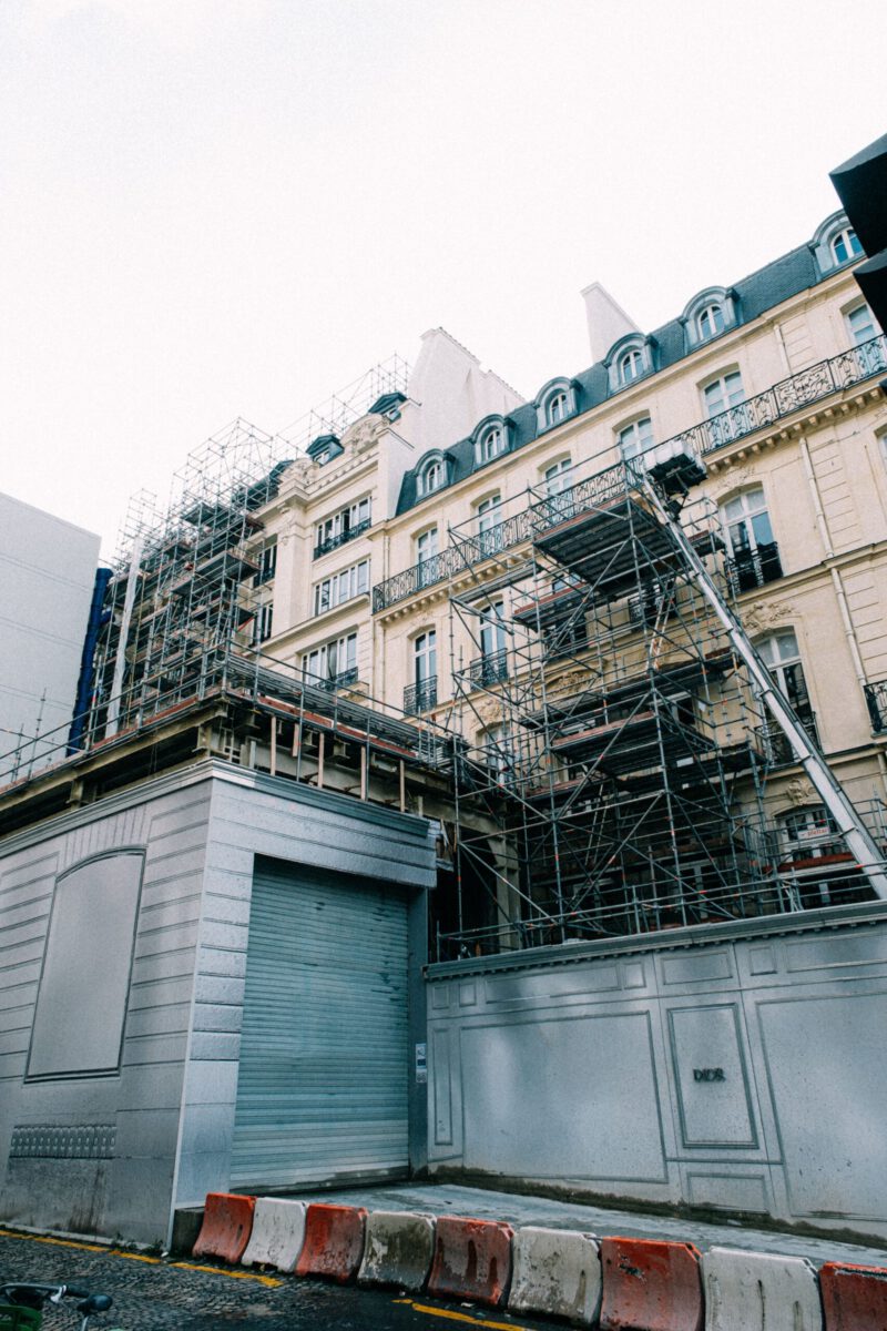 A historic building with scaffolding undergoing renovation in an urban area.